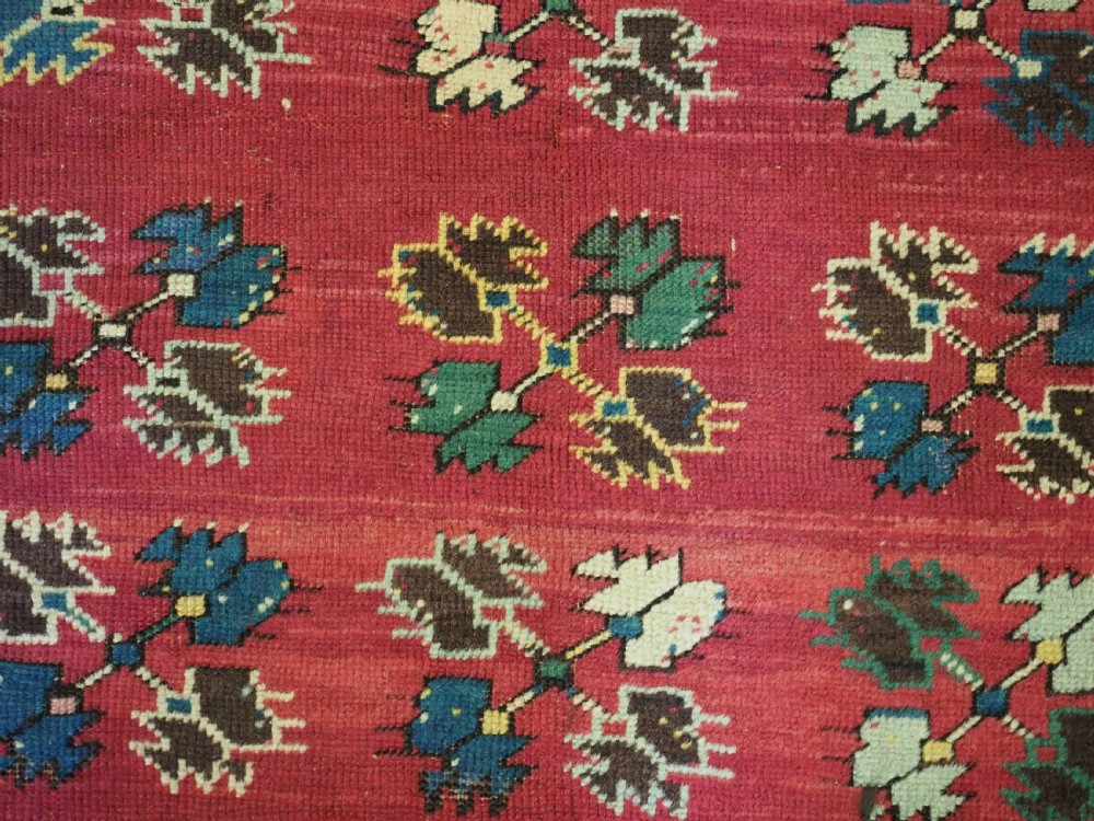 An antique hand-knotted Anatolian Kirsehir prayer rug featuring a central red arch motif framed by green sections and geometric borders. View VII