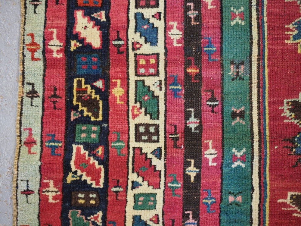 An antique hand-knotted Anatolian Kirsehir prayer rug featuring a central red arch motif framed by green sections and geometric borders. View VIII