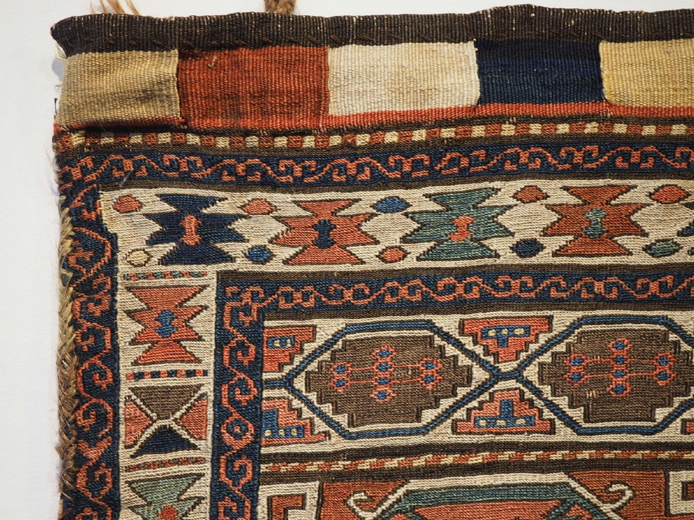 An antique flatwoven wool Shahsavan khorjin bag face featuring geometric octagonal medallions and running dog borders in terracotta red, indigo blue, cream, and sage green. View II