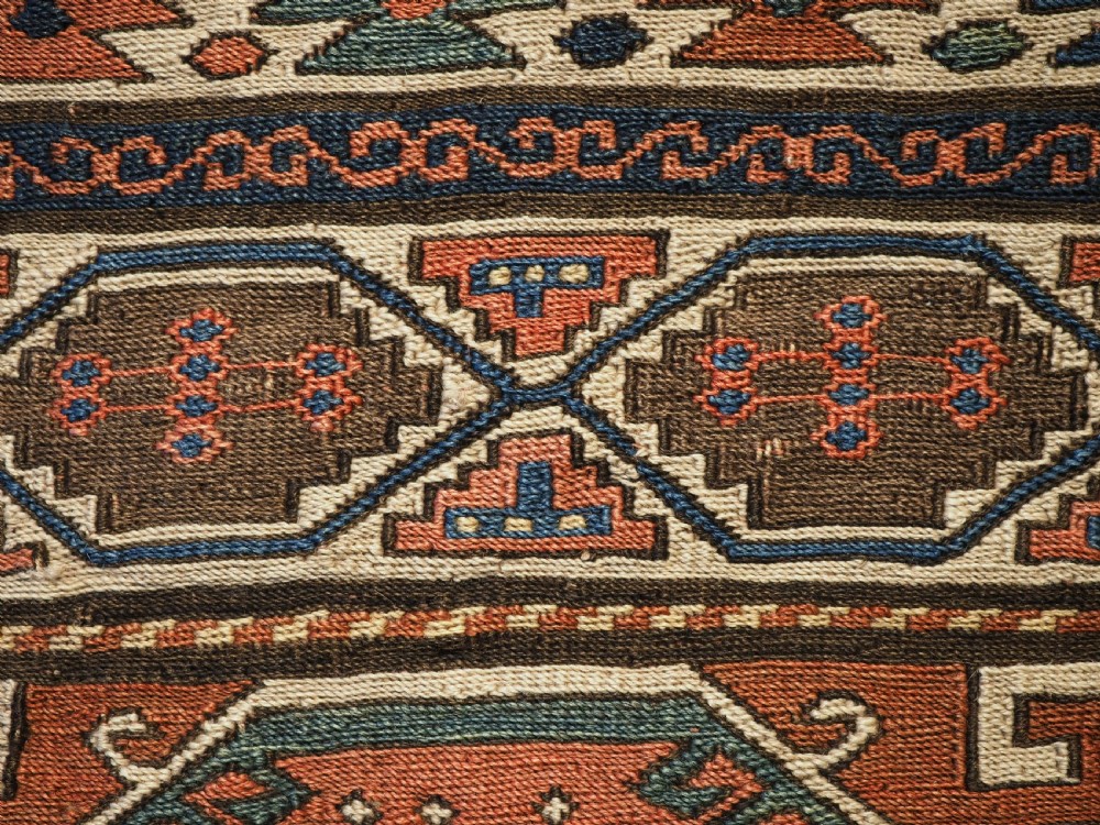 An antique flatwoven wool Shahsavan khorjin bag face featuring geometric octagonal medallions and running dog borders in terracotta red, indigo blue, cream, and sage green. View VII