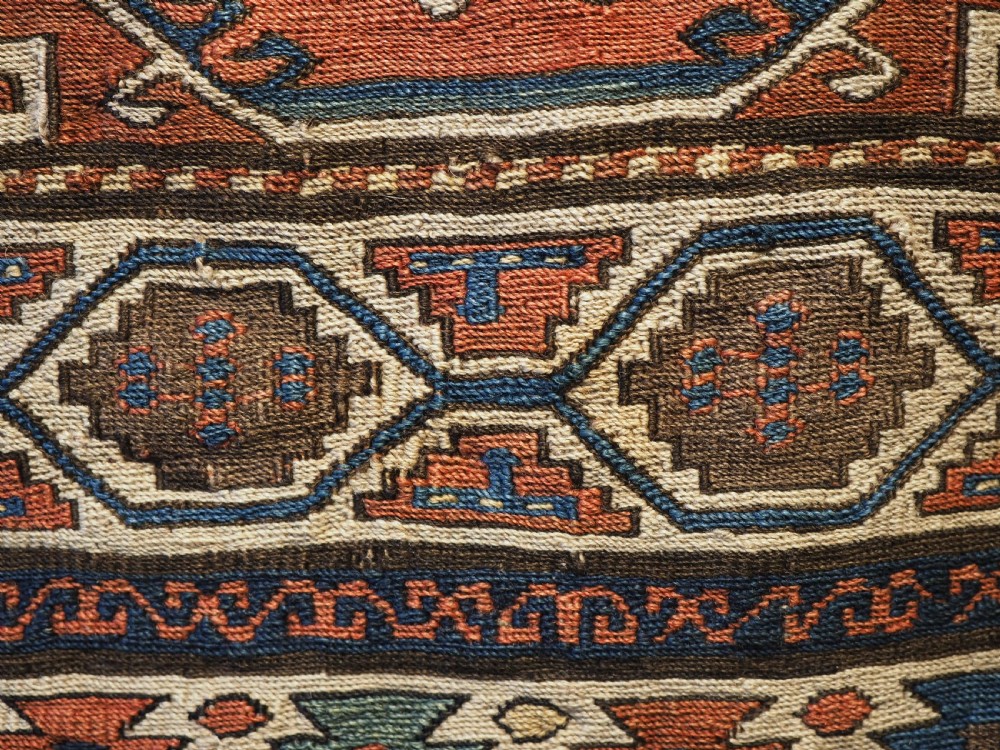 An antique flatwoven wool Shahsavan khorjin bag face featuring geometric octagonal medallions and running dog borders in terracotta red, indigo blue, cream, and sage green. View VIII