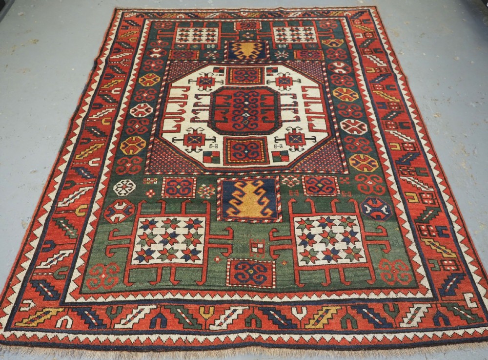 ANTIQUE CAUCASIAN KARACHOV KAZAK RUG WITH GREEN GROUND, CIRCA 1890.