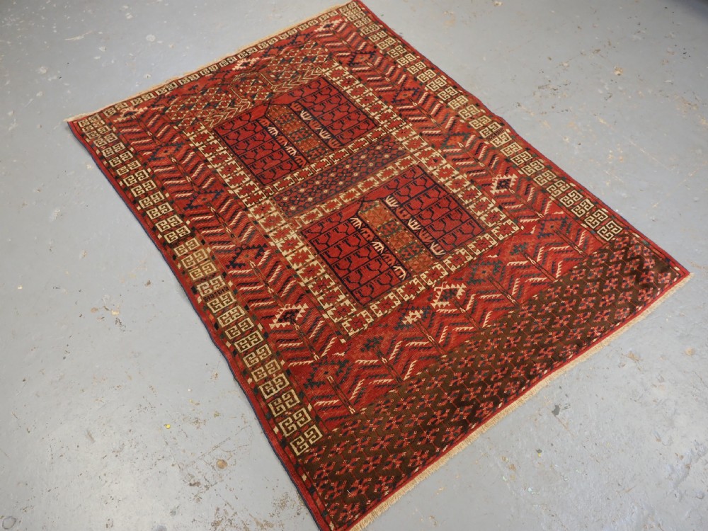 A hand-knotted wool Tekke Turkmen Ensi rug featuring a terracotta red field divided into four panels with dark geometric motifs and intricate borders. View II