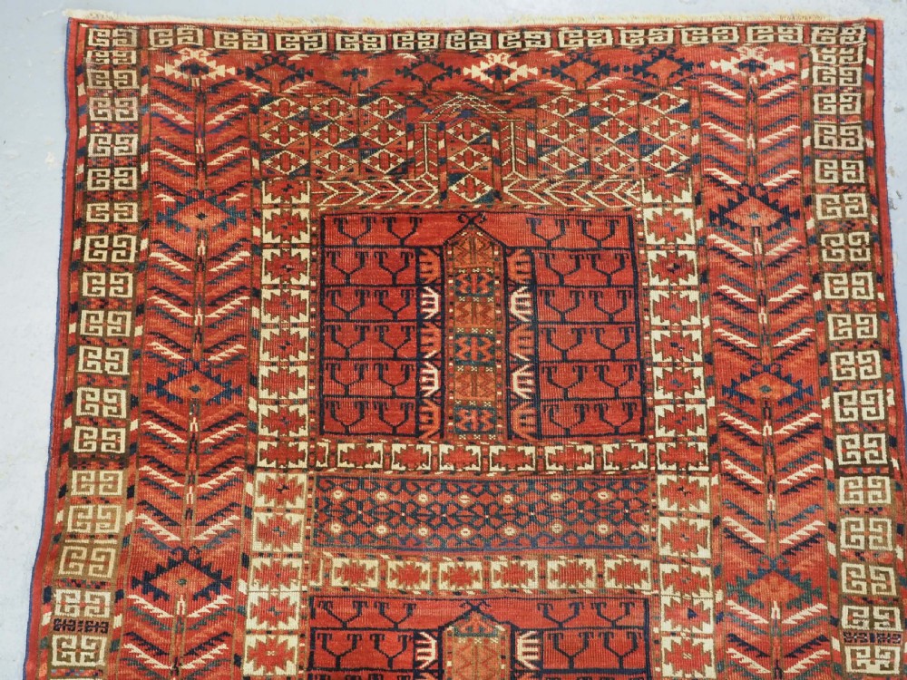 A hand-knotted wool Tekke Turkmen Ensi rug featuring a terracotta red field divided into four panels with dark geometric motifs and intricate borders. View III