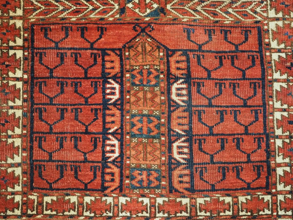 A hand-knotted wool Tekke Turkmen Ensi rug featuring a terracotta red field divided into four panels with dark geometric motifs and intricate borders. View XI