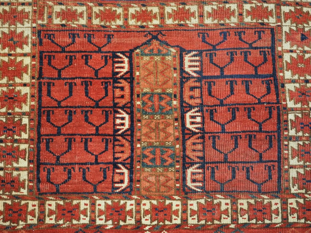 A hand-knotted wool Tekke Turkmen Ensi rug featuring a terracotta red field divided into four panels with dark geometric motifs and intricate borders. View XII