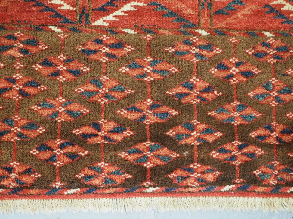 A hand-knotted wool Tekke Turkmen Ensi rug featuring a terracotta red field divided into four panels with dark geometric motifs and intricate borders. View XIII