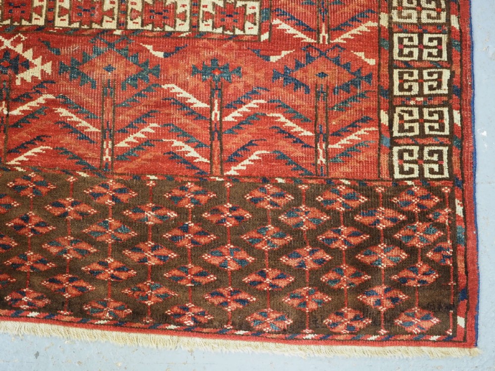 A hand-knotted wool Tekke Turkmen Ensi rug featuring a terracotta red field divided into four panels with dark geometric motifs and intricate borders. View XIV