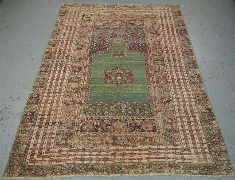 ANTIQUE TURKISH GHIORDES PRAYER RUG, MULTIPLE BORDERS, GREEN FIELD, CIRCA 1750.