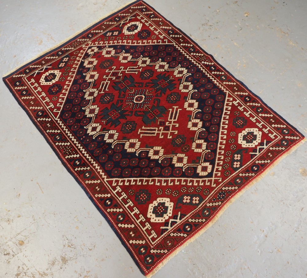 An antique hand-knotted Turkish Kiz Bergama wool rug featuring a red field, central diamond medallion, navy blue accents, and geometric borders. View II