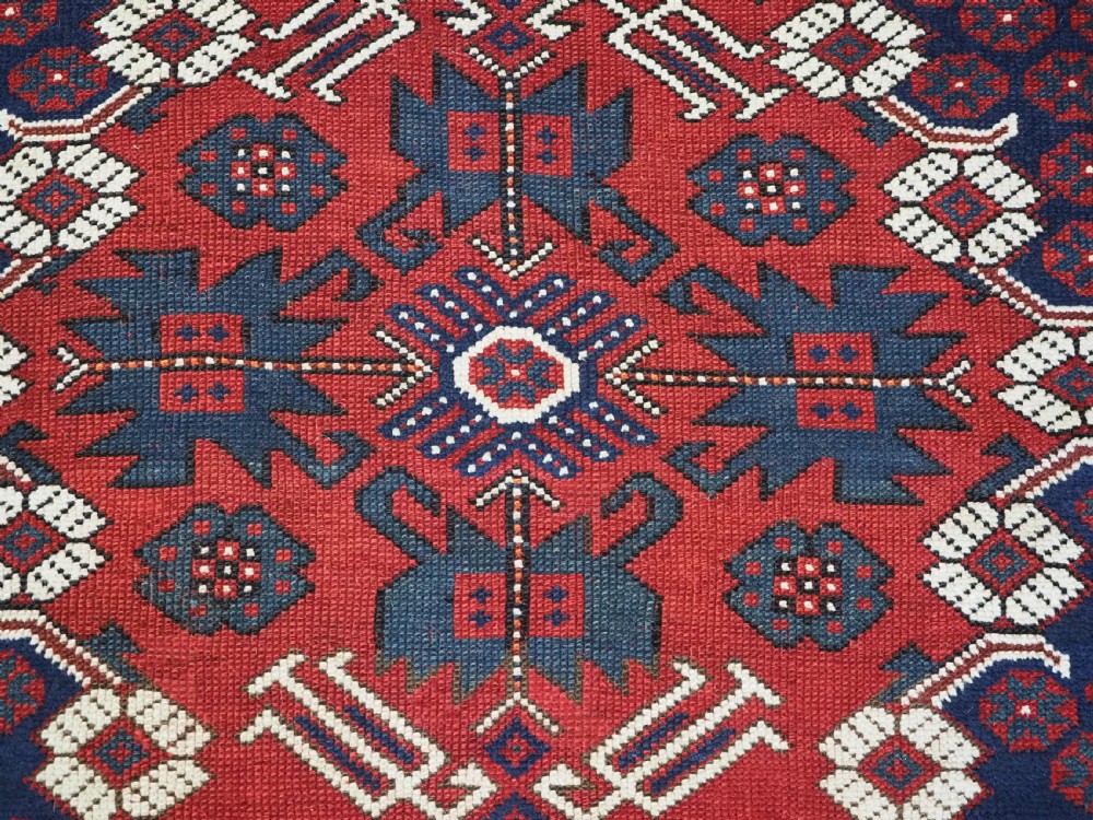 An antique hand-knotted Turkish Kiz Bergama wool rug featuring a red field, central diamond medallion, navy blue accents, and geometric borders. View XI