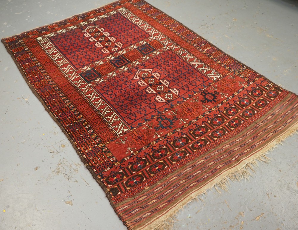 An antique hand-knotted Ersari Turkmen Ensi wool rug featuring deep red tones, a central cruciform design, geometric borders, and a woven fringe. View II