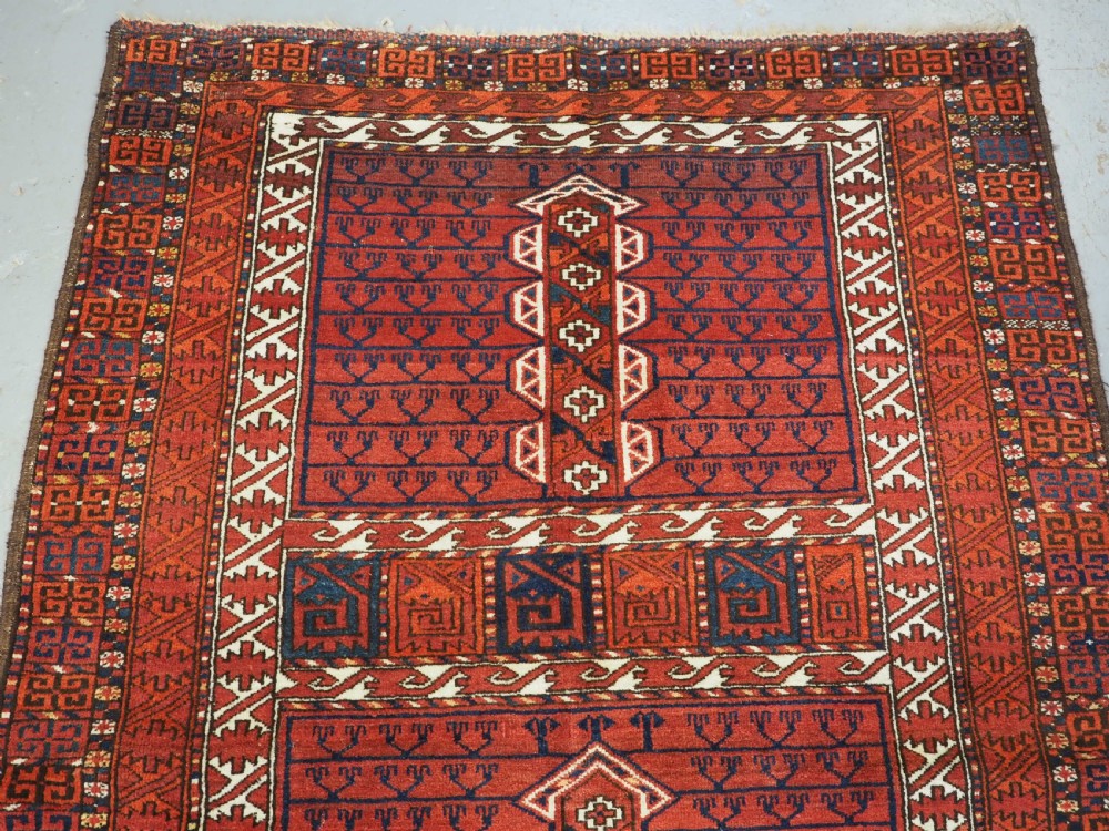 An antique hand-knotted Ersari Turkmen Ensi wool rug featuring deep red tones, a central cruciform design, geometric borders, and a woven fringe. View III