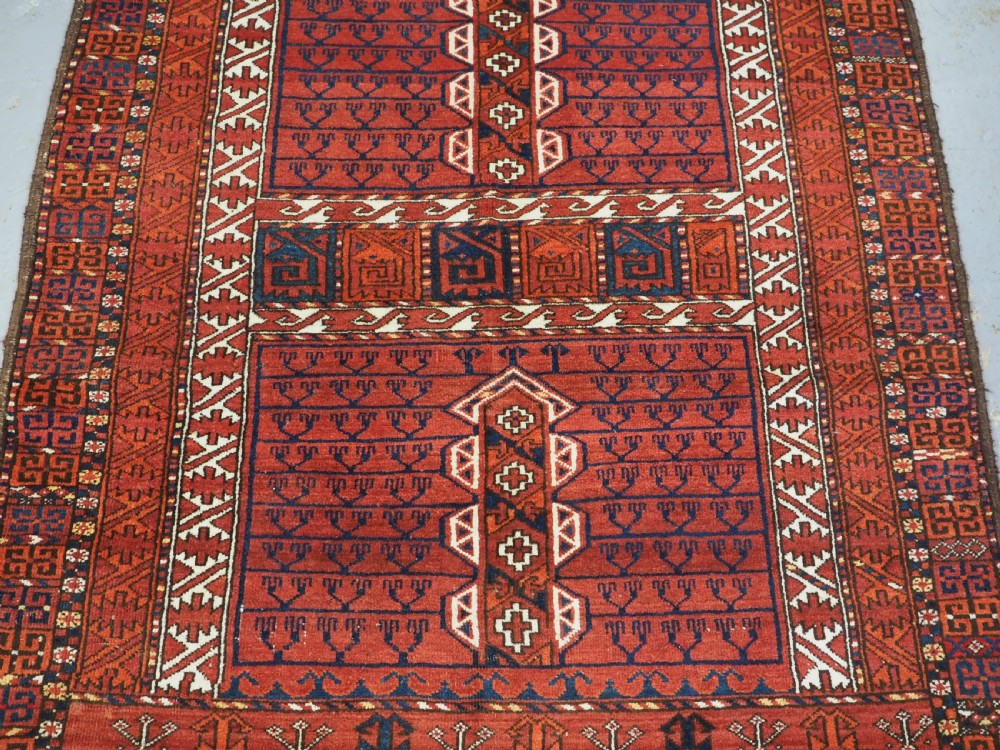 An antique hand-knotted Ersari Turkmen Ensi wool rug featuring deep red tones, a central cruciform design, geometric borders, and a woven fringe. View IV