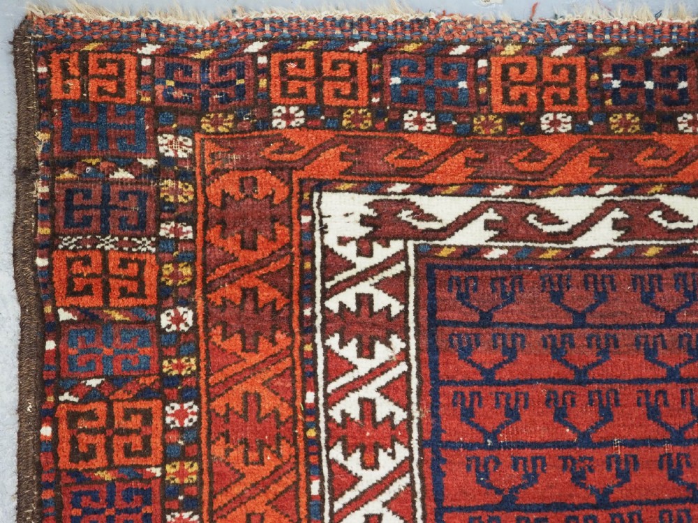 An antique hand-knotted Ersari Turkmen Ensi wool rug featuring deep red tones, a central cruciform design, geometric borders, and a woven fringe. View VI