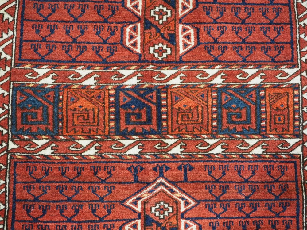An antique hand-knotted Ersari Turkmen Ensi wool rug featuring deep red tones, a central cruciform design, geometric borders, and a woven fringe. View VIII
