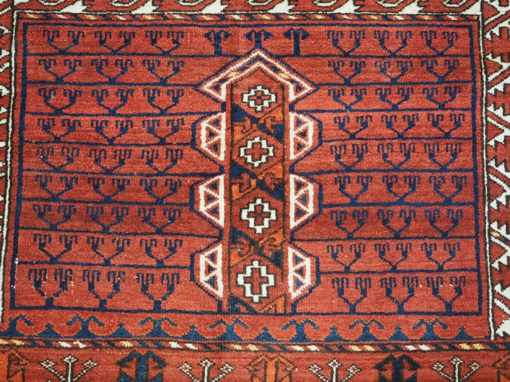 An antique hand-knotted Ersari Turkmen Ensi wool rug featuring deep red tones, a central cruciform design, geometric borders, and a woven fringe. View IX