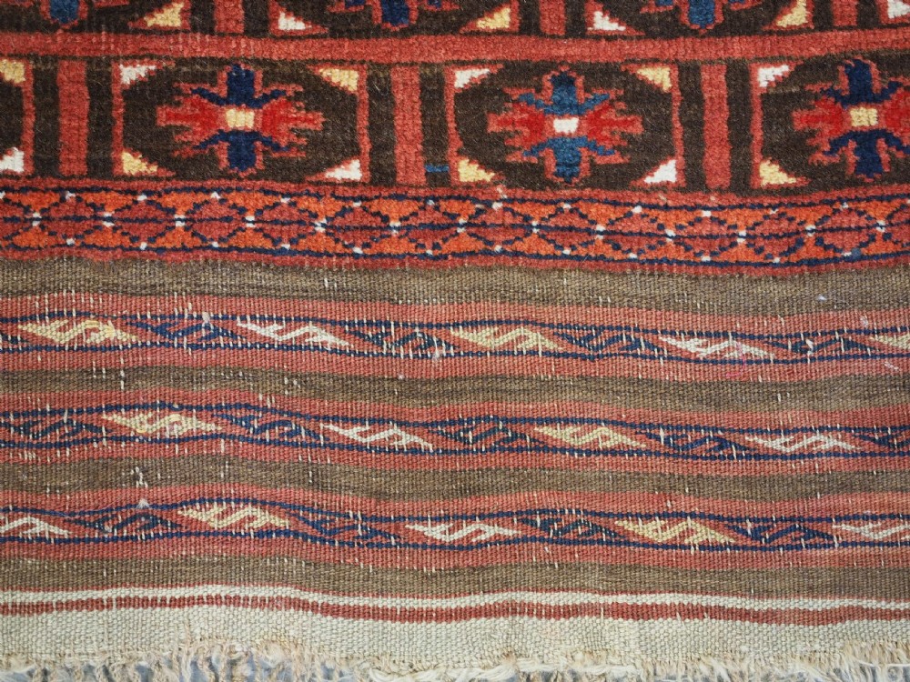 An antique hand-knotted Ersari Turkmen Ensi wool rug featuring deep red tones, a central cruciform design, geometric borders, and a woven fringe. View XI