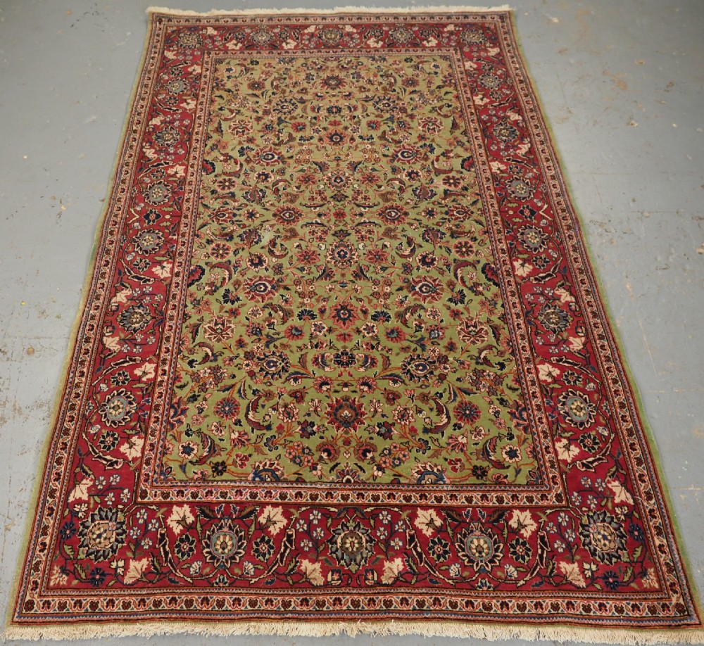 ANTIQUE KASHAN RUG WITH FINE FLORAL DESIGN ON A SCARCE GREEN GROUND, CIRCA 1900.
