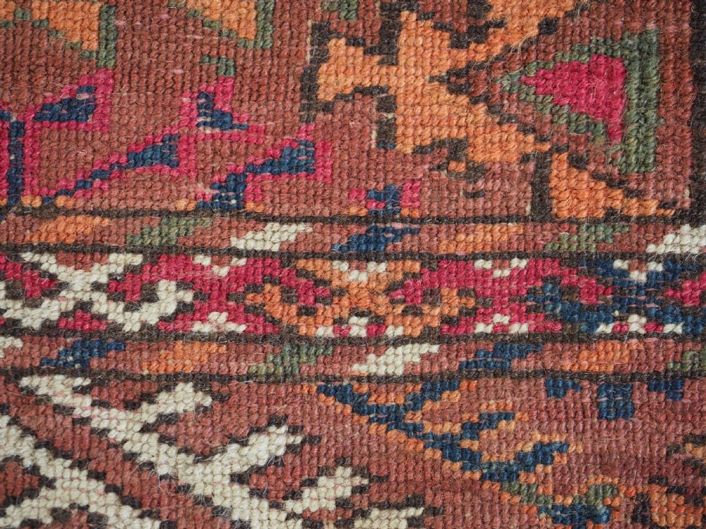 An antique Tekke Turkmen wool area rug featuring a repeating grid of octagonal gol motifs on a deep rust-red field with decorative geometric borders. View XII