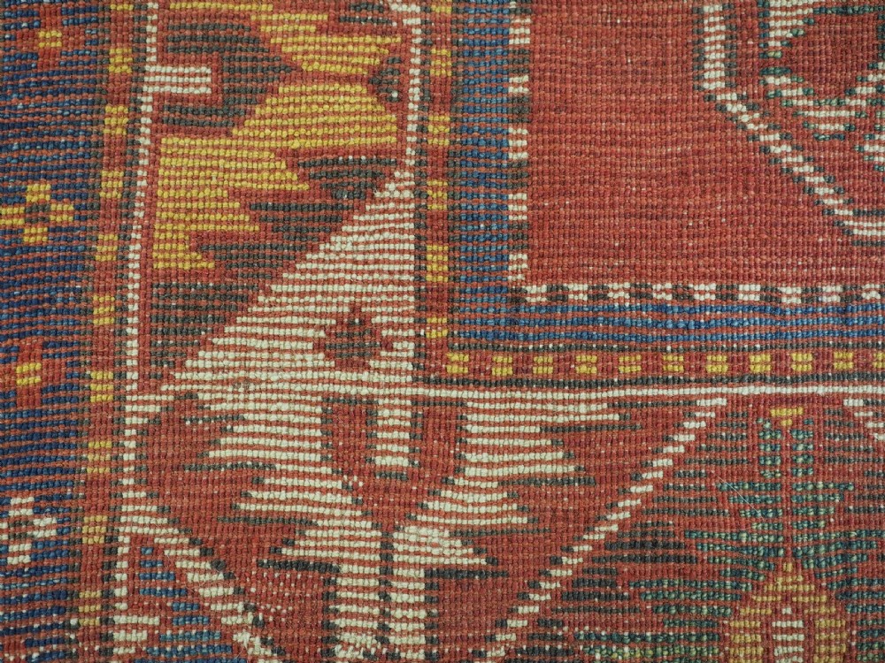 An antique hand-knotted Caucasian Fachralo Kazak prayer rug featuring a red field with green diamond medallions and a geometric border. View XI