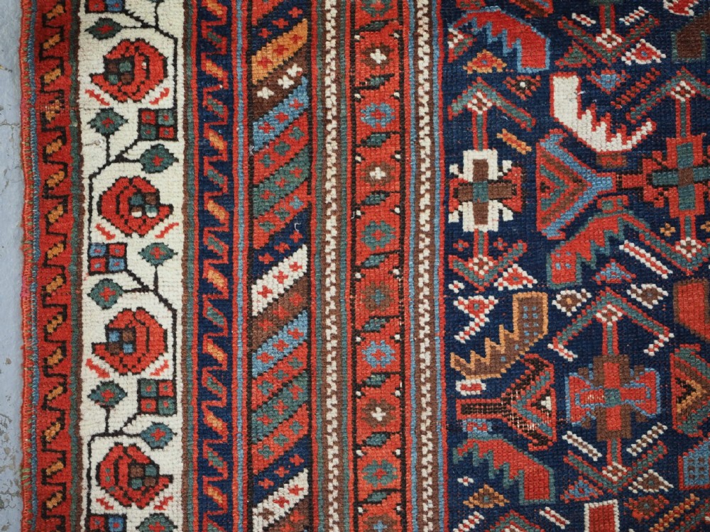 An antique hand-knotted wool Afshar rug featuring an all-over geometric Herati design on a dark navy blue field with a patterned cream border. View VII