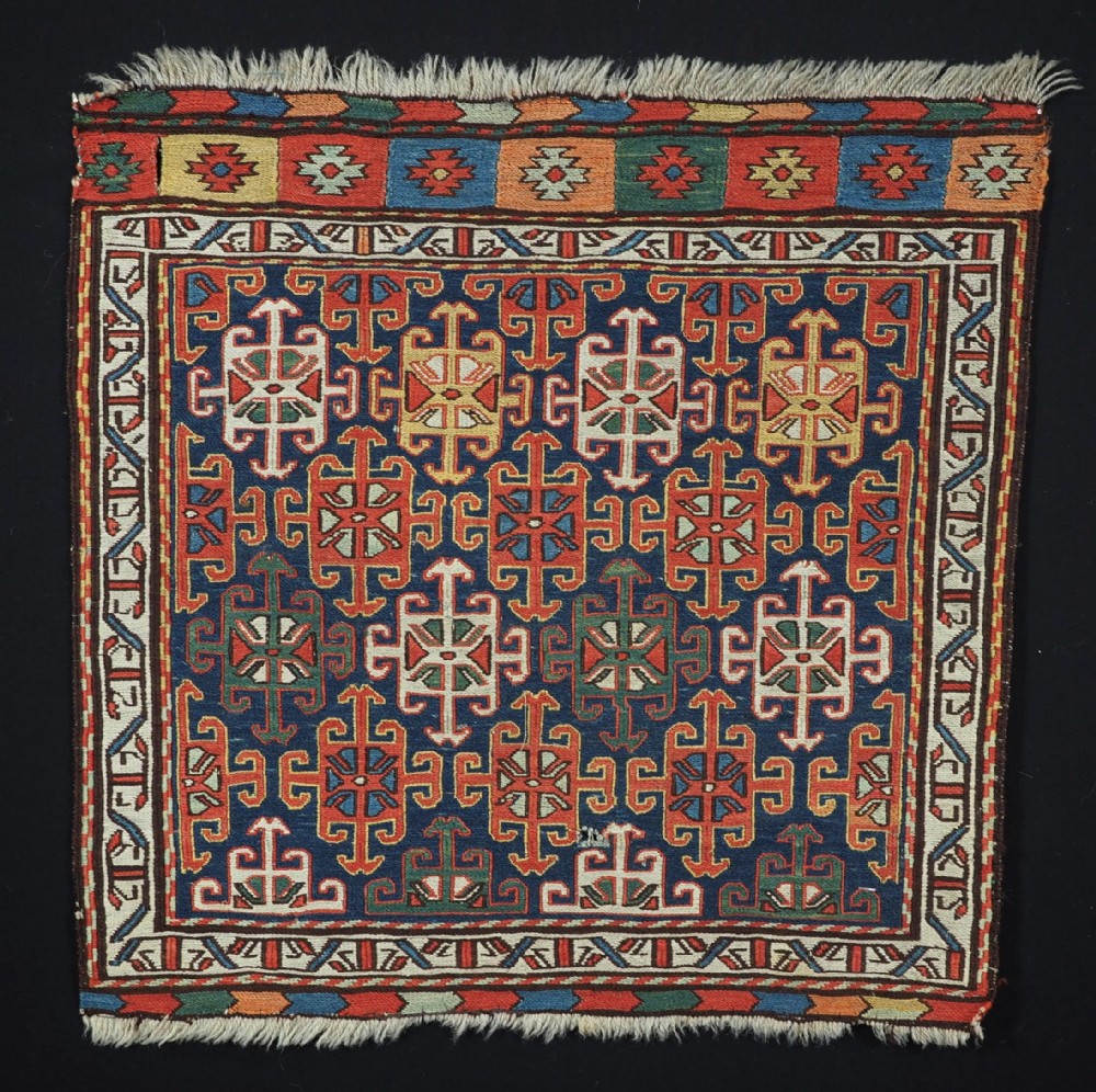 An antique square Shahsavan wool bag face featuring geometric tribal motifs woven in Soumak flatweave technique with red, blue, green, and cream hues.