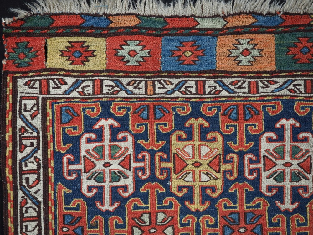 An antique square Shahsavan wool bag face featuring geometric tribal motifs woven in Soumak flatweave technique with red, blue, green, and cream hues. View II