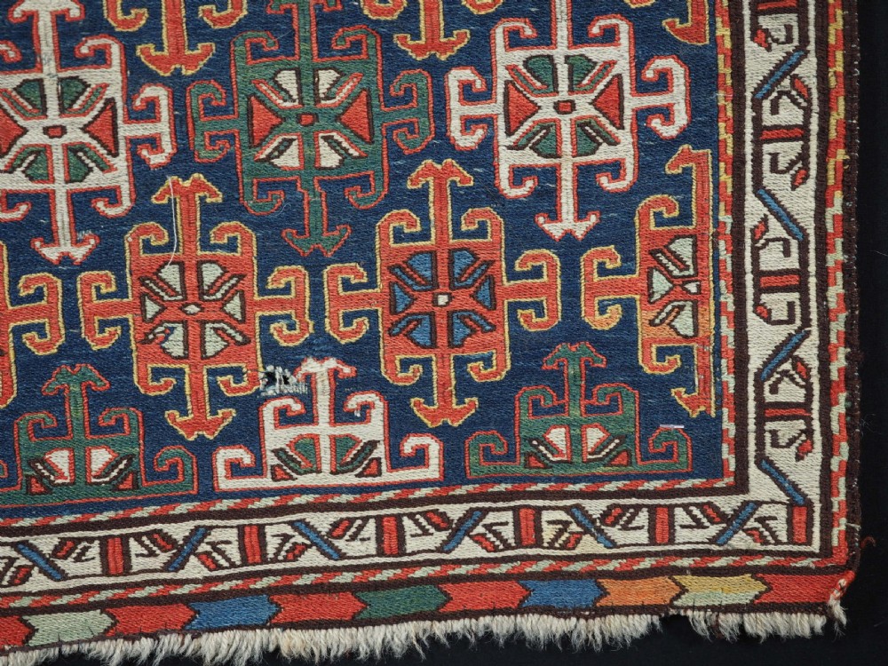An antique square Shahsavan wool bag face featuring geometric tribal motifs woven in Soumak flatweave technique with red, blue, green, and cream hues. View V