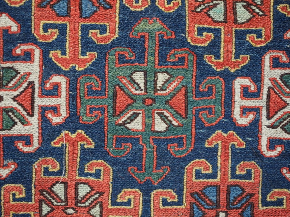 An antique square Shahsavan wool bag face featuring geometric tribal motifs woven in Soumak flatweave technique with red, blue, green, and cream hues. View VII