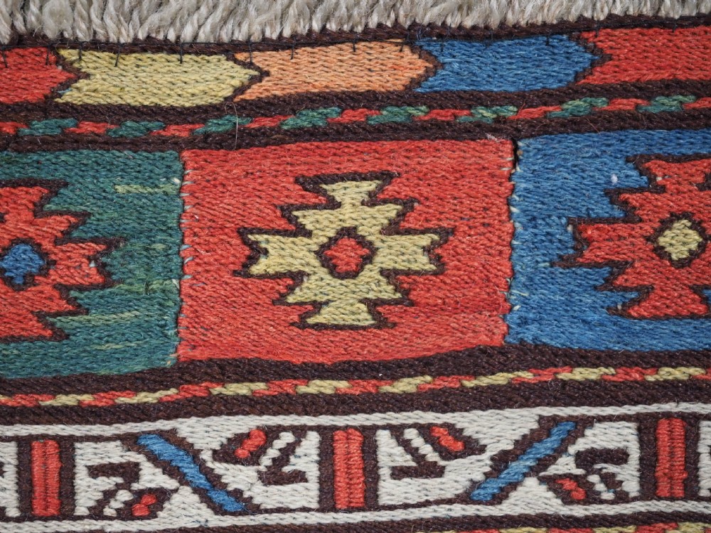 An antique square Shahsavan wool bag face featuring geometric tribal motifs woven in Soumak flatweave technique with red, blue, green, and cream hues. View IX