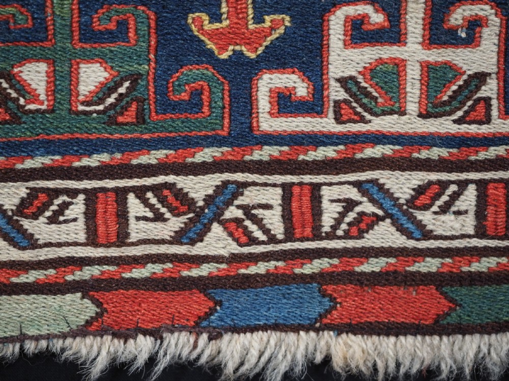An antique square Shahsavan wool bag face featuring geometric tribal motifs woven in Soumak flatweave technique with red, blue, green, and cream hues. View X