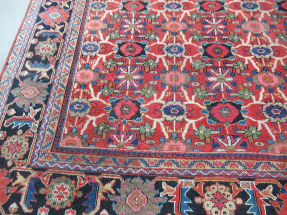 A large antique Persian Mahal wool carpet featuring a red field with an all-over floral Mina Khani lattice pattern framed by a dark navy decorative border. View II