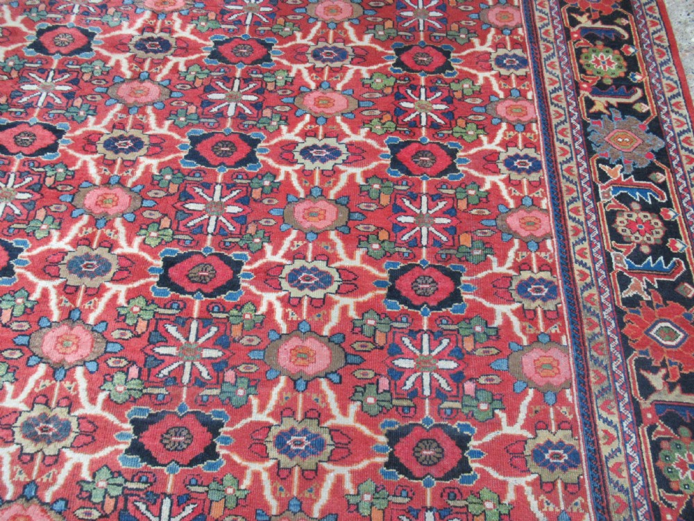 A large antique Persian Mahal wool carpet featuring a red field with an all-over floral Mina Khani lattice pattern framed by a dark navy decorative border. View III