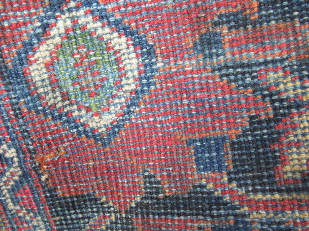 A large antique Persian Mahal wool carpet featuring a red field with an all-over floral Mina Khani lattice pattern framed by a dark navy decorative border. View IV