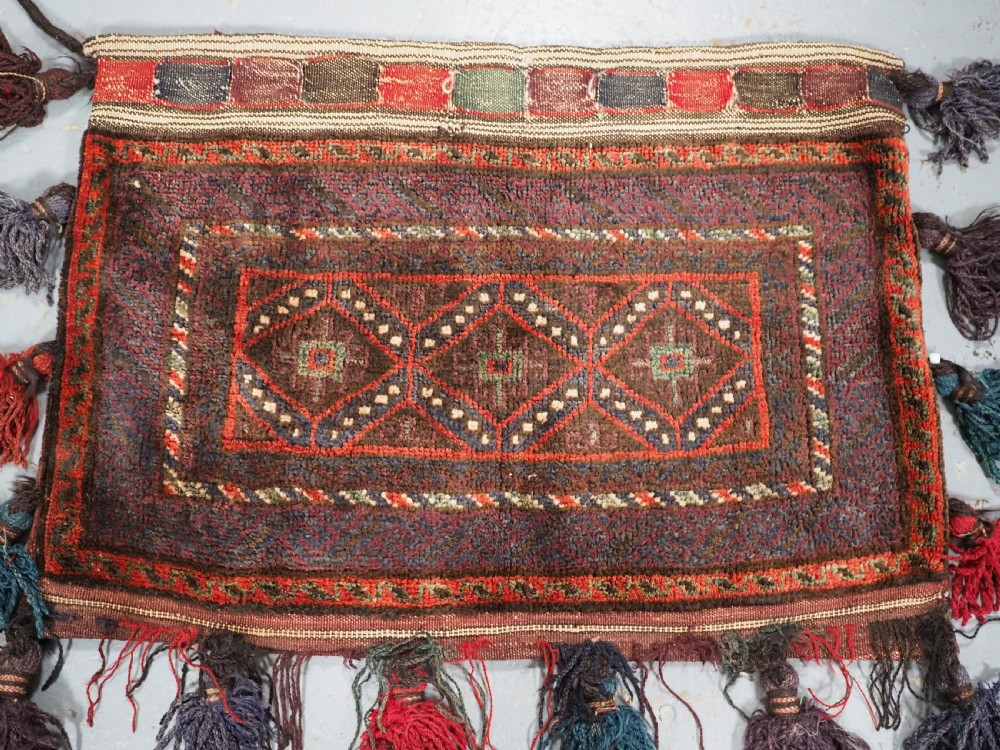 ANTIQUE AFGHAN TRIBAL STORAGE BAG COMPLETE WITH TASSELS, CIRCA 1920. View II