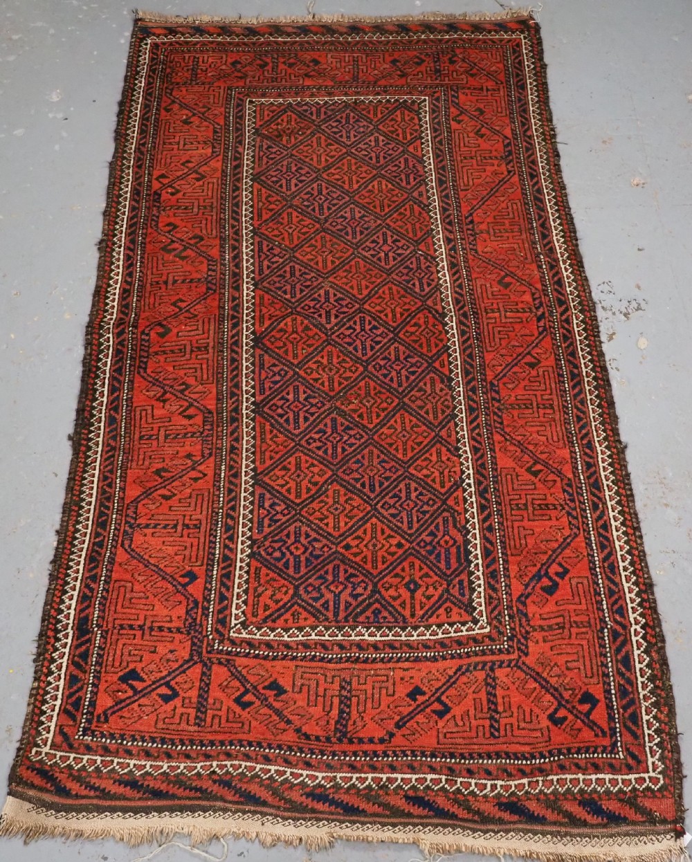 ANTIQUE AFGHAN BALUCH RUG WITH LATTICE DESIGN, CIRCA 1900.