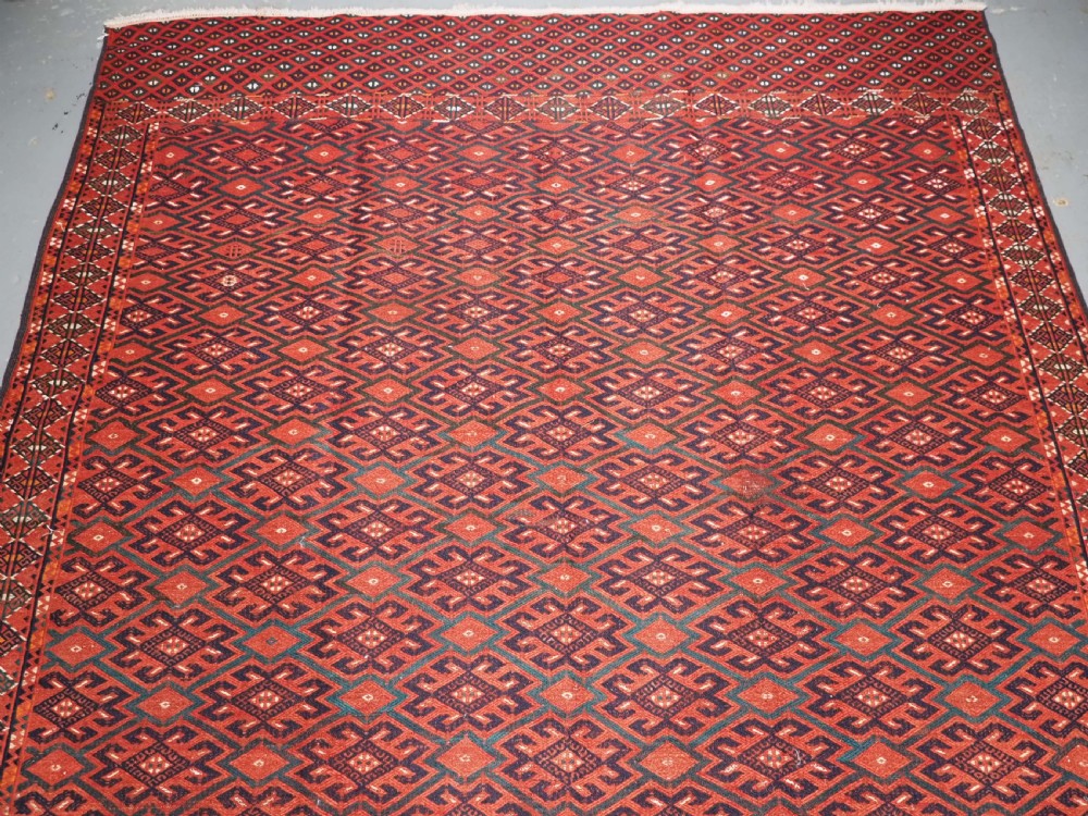 A large rectangular deep red wool flatweave carpet featuring an all-over diamond lattice pattern with detailed geometric borders and palas ends. View III