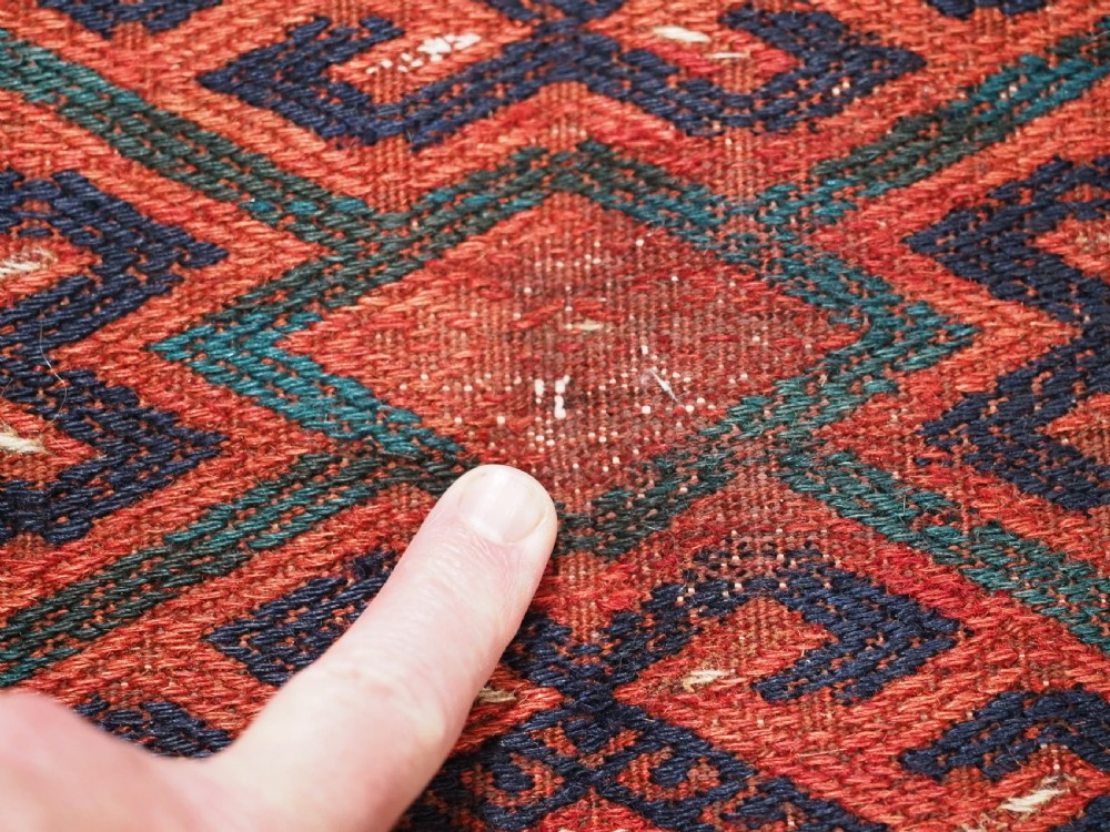 A large rectangular deep red wool flatweave carpet featuring an all-over diamond lattice pattern with detailed geometric borders and palas ends. View VII