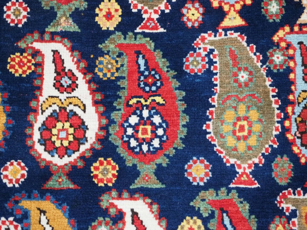 An antique Caucasian Karabagh hand-knotted wool runner rug featuring repeating multi-coloured boteh patterns on a dark navy field surrounded by a red floral border. View XI