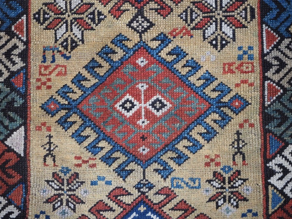 An antique South Caucasian hand-knotted wool rug with a vibrant yellow central field, diamond medallions, and ornate multi-coloured geometric borders. View X
