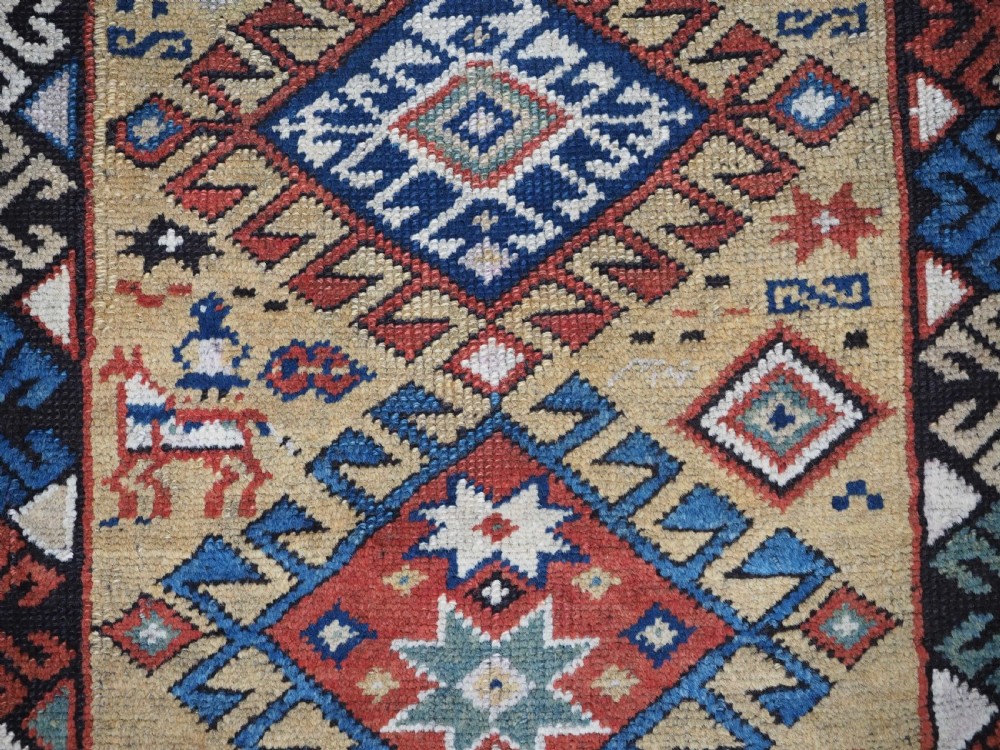 An antique South Caucasian hand-knotted wool rug with a vibrant yellow central field, diamond medallions, and ornate multi-coloured geometric borders. View XI