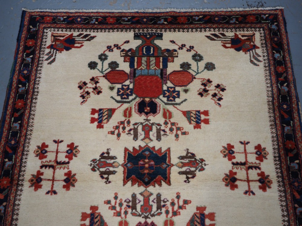 A hand-woven antique Afshar wool rug featuring geometric vase motifs in red, navy, and green on an ivory field with a dark border. View III