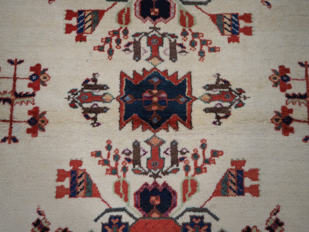 A hand-woven antique Afshar wool rug featuring geometric vase motifs in red, navy, and green on an ivory field with a dark border. View IX