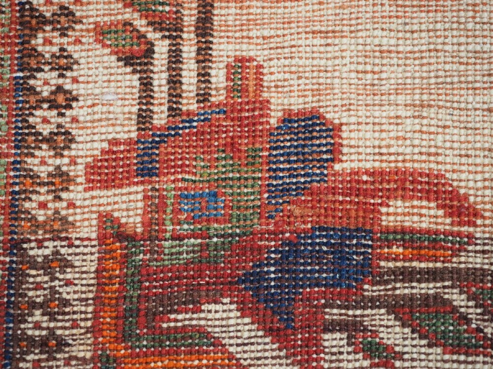 A hand-woven antique Afshar wool rug featuring geometric vase motifs in red, navy, and green on an ivory field with a dark border. View X