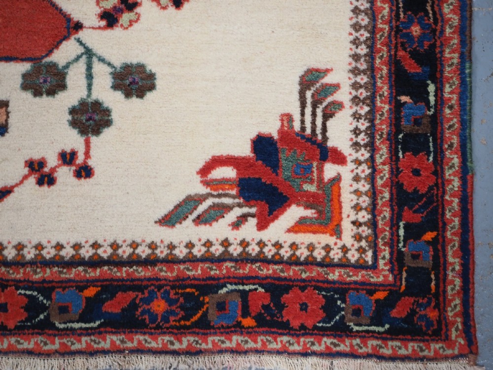 A hand-woven antique Afshar wool rug featuring geometric vase motifs in red, navy, and green on an ivory field with a dark border. View XI