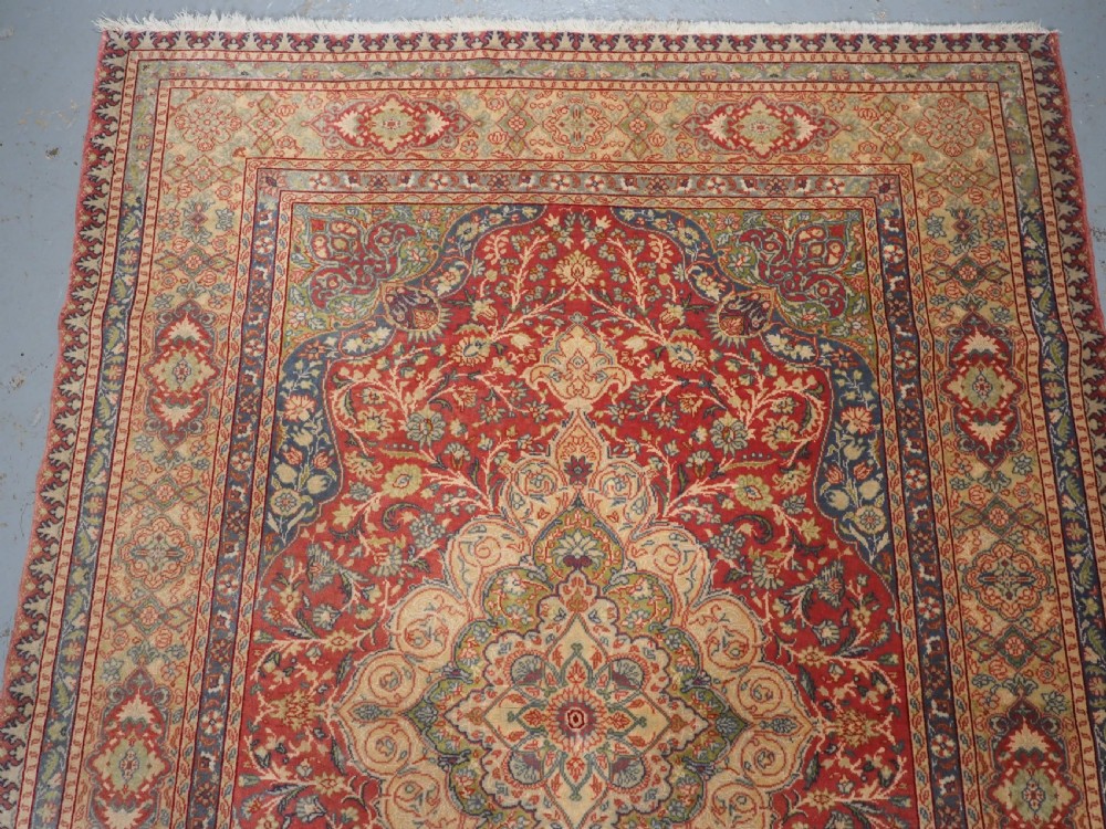 An antique Anatolian Sivas hand-knotted wool rug featuring a central cream medallion surrounded by a red field with floral arabesques and multi-tiered borders. View III