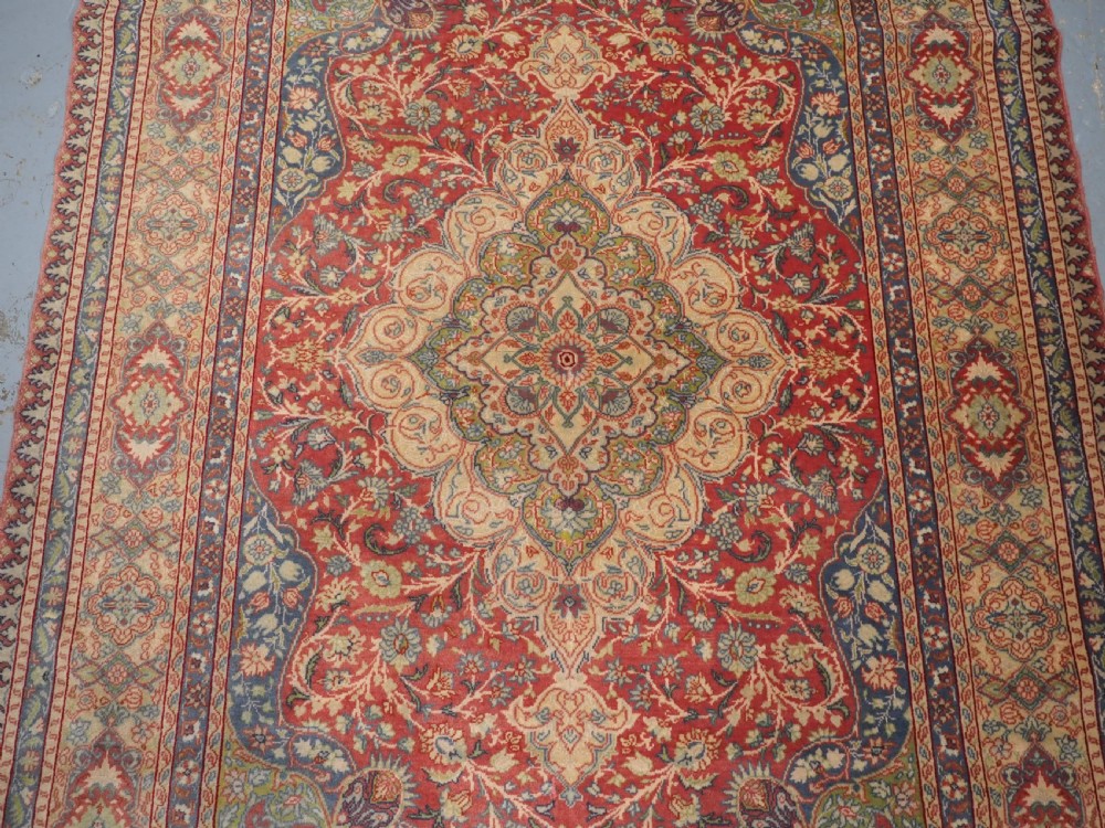An antique Anatolian Sivas hand-knotted wool rug featuring a central cream medallion surrounded by a red field with floral arabesques and multi-tiered borders. View IV