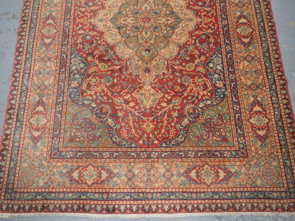 An antique Anatolian Sivas hand-knotted wool rug featuring a central cream medallion surrounded by a red field with floral arabesques and multi-tiered borders. View V