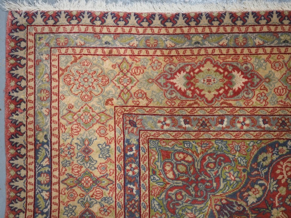 An antique Anatolian Sivas hand-knotted wool rug featuring a central cream medallion surrounded by a red field with floral arabesques and multi-tiered borders. View VI